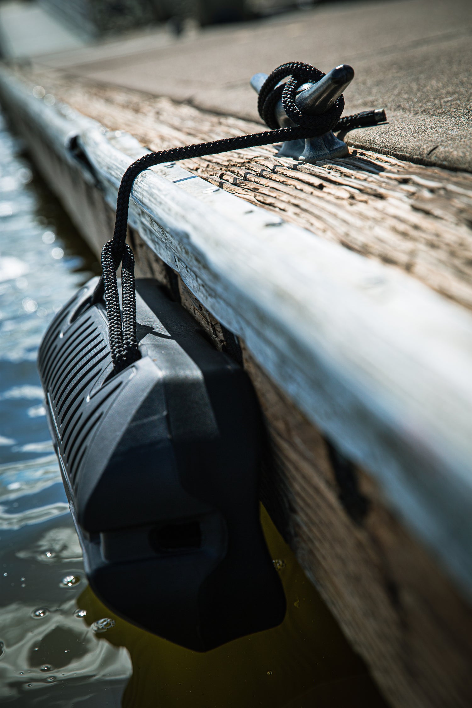Fatsac boat bumper floats near the surface, tied to a dock line.
