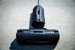 Fatsac black boat fender with straps on a concrete dock.