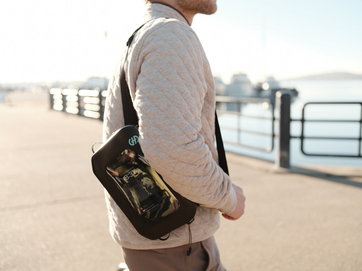Lifestyle image of person wearing Hip Pack cross-body with phone visible through clear window.