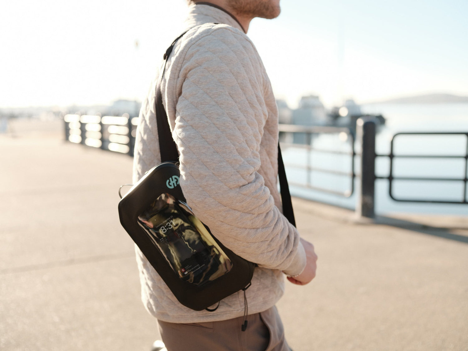Lifestyle image of person wearing Hip Pack cross-body with phone visible through clear window.