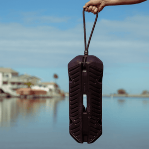 Person holding a Fatsac black fender and dock line by a lakeside.